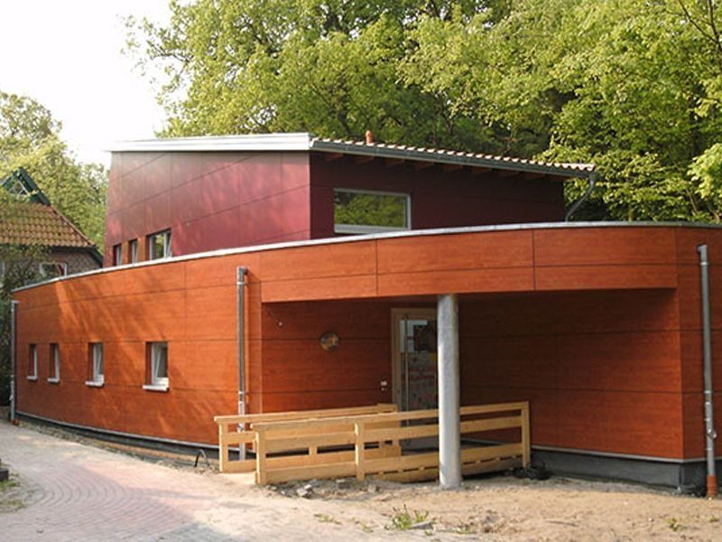 Ein Holzhaus mit einem geschwungenen Dach, das eine harmonische und einladende Architektur ausstrahlt.