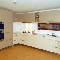 Eine moderne Küche mit einem Spülbecken, einem Herd und einem Kühlschrank, die funktional und einladend wirkt.