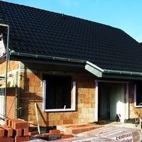 Ein im Bau befindliches Haus mit Ziegeln und einem gefliesten Dach.