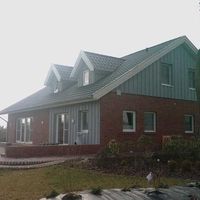 Ein Haus mit einer großen Veranda vorne und einer kleinen Veranda hinten.