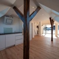 Ein Loft mit Holzbohlen und einer modernen Küche, die eine einladende Atmosphäre schafft.
