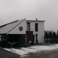 Ein Haus mit einem Auto, das davor geparkt ist, in einer ruhigen Wohngegend.