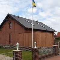 Ein Haus mit einem Fahnenmast davor, der die nationale Flagge weht.