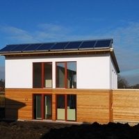 Ein Haus mit Solarpanelen auf dem Dach, das umweltfreundliche Energie erzeugt und nachhaltiges Wohnen fördert.