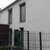 Ein Haus, umgeben von einem Zaun, der das Grundstück vollständig umschließt.